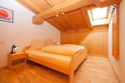 蒂罗尔州圣约翰Vorderstockerhof的一间带一张床的卧室,位于带木制天花板的房间内