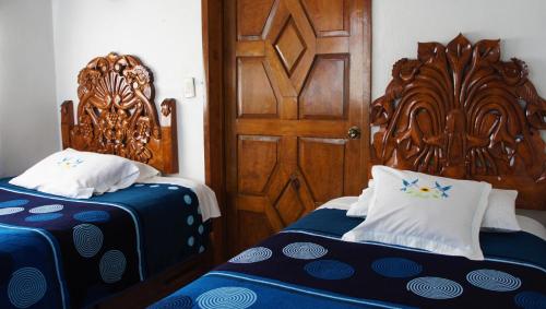 圣胡安特奥蒂瓦坎Posada y Spa Jade Teotihuacan的一间卧室设有两张床和木门
