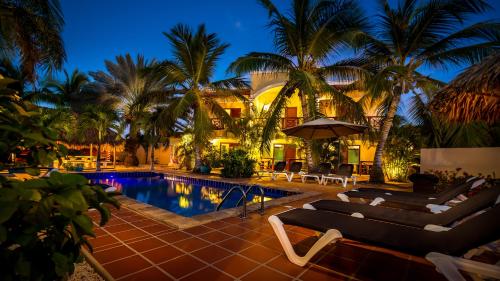 克拉伦代克松里萨精品酒店的夜间带游泳池和棕榈树的度假村