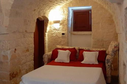 马丁纳弗兰卡Trullo Pentimelle的一间卧室配有红色和白色枕头的床