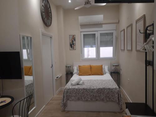 马拉加马可德拉麦西德公寓的卧室配有一张床,墙上挂着一个钟