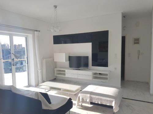 拉里萨NN Larisa Deluxe Apartment的白色的客厅配有电视和沙发