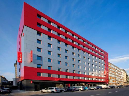 日内瓦日内瓦国家中心宜必思酒店的一座红色的建筑,汽车停在停车场