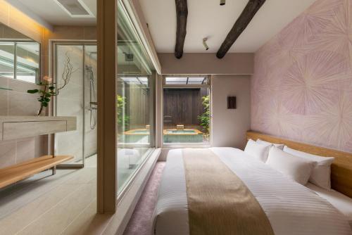 京都Nazuna Kyoto Tsubaki St.的一间卧室设有一张大床和一个大窗户