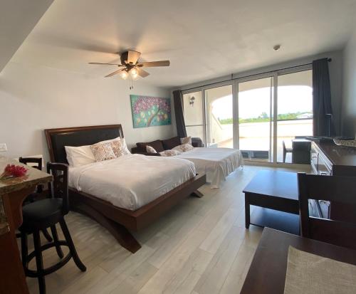 Turtle CoveLa Vista Azul Resort - Studio的一间卧室配有两张床和吊扇