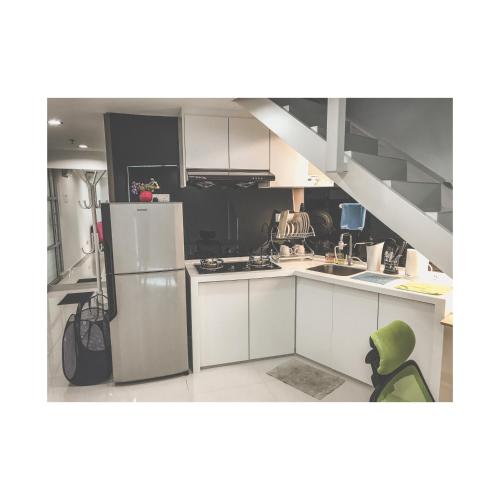 峇六拜The ceo suites by Zenbnb的厨房配有白色橱柜和冰箱。
