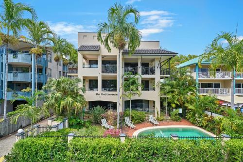 约克斯诺波Mediterranean Beachfront Apartments的公寓大楼设有游泳池和棕榈树