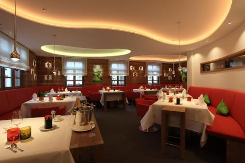 拉尔埃德尔餐厅-酒店的一间设有桌子和红色摊位的餐厅