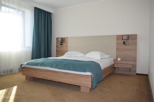 布拉索夫雷格尔酒店的一间卧室配有一张带绿毯的大床