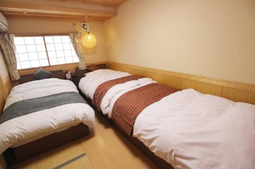 NeyagawaYadokari Osaka的卧室设有两张床,带窗户
