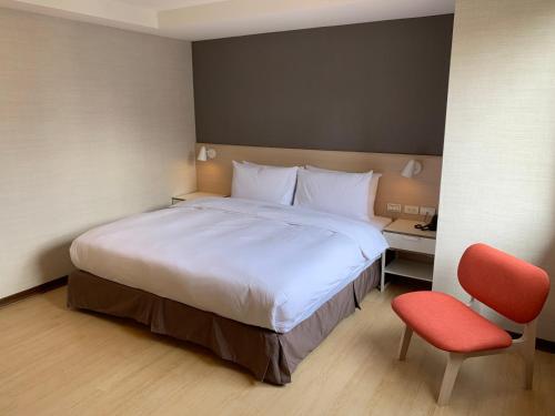 台北HATAGO+ THE ALLEY的一间卧室配有一张大床和一张红色椅子