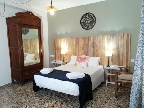 桑卢卡尔-德巴拉梅达Casa Algarabía的一间卧室配有一张大床和镜子