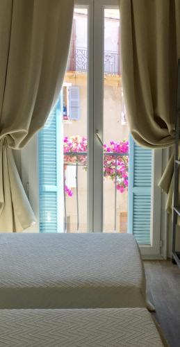 卡尔热斯Hotel Cyrnos的一间卧室设有一张床和一个大窗户