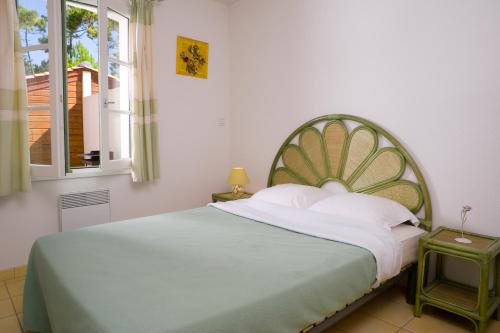 圣伊莱尔德里耶Madame Vacances les Mas de Saint Hilaire的一间卧室配有一张大床和绿色床头板