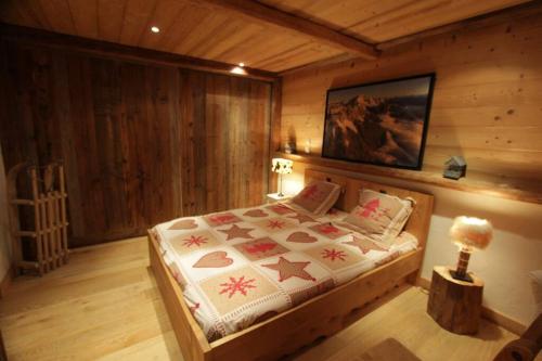 拉克吕萨appartement cozy dans chalet 6 pers voiture 4 roues motrice a dispo的木制客房内的一间卧室,配有一张床