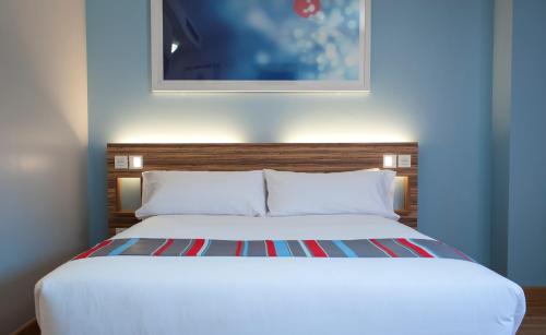 巴塞罗那巴塞罗那波布雷诺旅馆的卧室配有白色床,上面有绘画作品