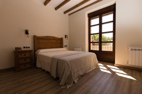 Ferreras de AbajoPosada Sierra de la Culebra的一间卧室设有一张大床和一个窗户。