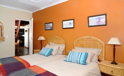 德尔斯特鲁姆斯通卡特斯旅舍的橙色墙壁客房的两张床