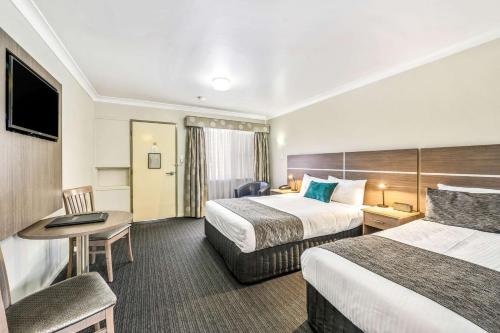 塔姆沃思Quality Inn Ashby House Tamworth的酒店客房配有两张床和一张书桌