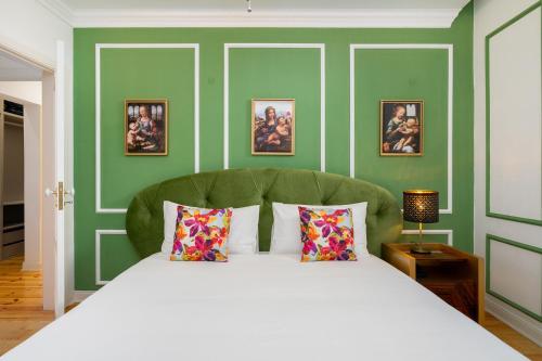 里斯本WHome | Great Location & Large Family Apartment w/Patio的一间卧室配有一张白色的床和绿色的墙壁