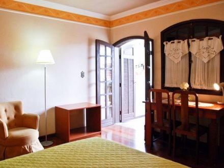 韦斯帕夏诺多姆奥托酒店的一间卧室配有一张床、一张桌子和一把椅子