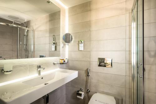 尼基亚娜波尔托加里尼海滨度假酒店&Spa的一间带水槽、卫生间和镜子的浴室