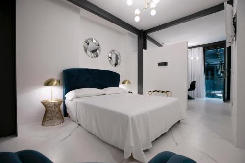 特拉帕尼Azzoli Trapani - Apartments&Skypool - Adults Only的白色卧室配有床和蓝椅