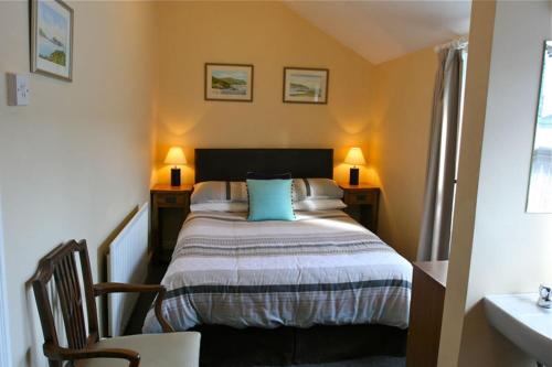 道格拉斯梅尔罗斯旅馆的一间卧室配有一张带两张桌子和两盏灯的床。