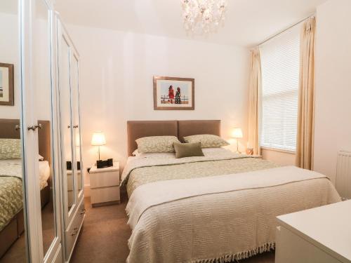 巴克斯顿2B Cavendish Villas的一间卧室配有一张大床和一个吊灯。