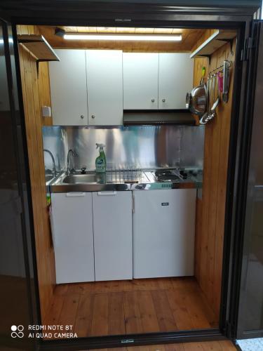 斯卡拉拉乔伊For Nature Lovers 2的厨房配有白色橱柜和水槽