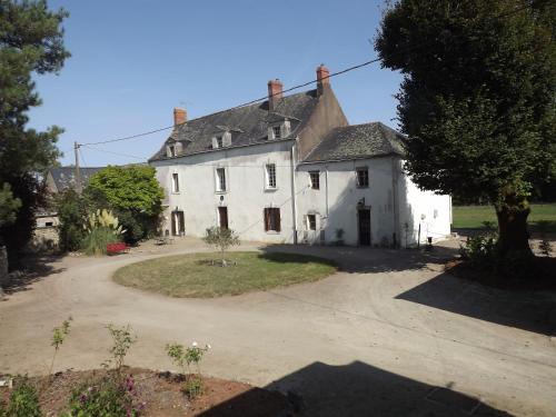 圣埃尔布兰Manoir de L'Aisnerie的前面有车道的白色旧房子