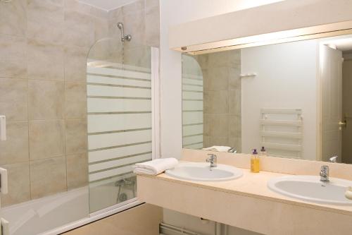 莫列马阿Madame Vacances Residence Du Golf的浴室设有2个水槽和镜子