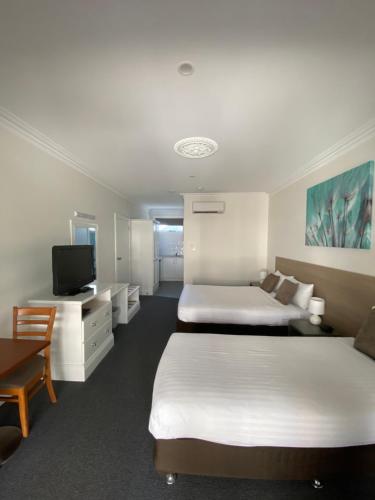 伊丘卡Campaspe Lodge的酒店客房设有两张床和一台平面电视。