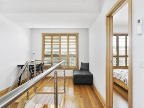 莱伊黑麦漂流木公寓的客房设有楼梯、床和窗户。