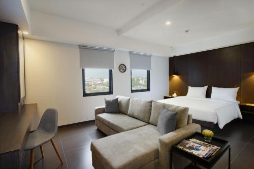 日惹Malioboro Prime Hotel的酒店客房,配有床和沙发