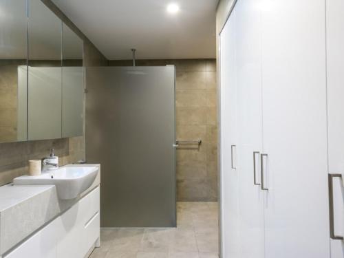 莱伊黑麦漂流木公寓的白色的浴室设有水槽和淋浴。