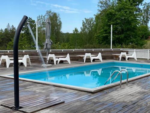 本茨福什贝亲斯弗斯第一酒店的木制甲板上的游泳池,配有椅子和桌子