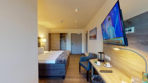 帕彭堡WH Hotels Papenburg Zentrum的配有床和书桌的酒店客房
