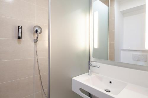 马西B&B HOTEL Massy Gare TGV的带淋浴、盥洗盆和镜子的浴室