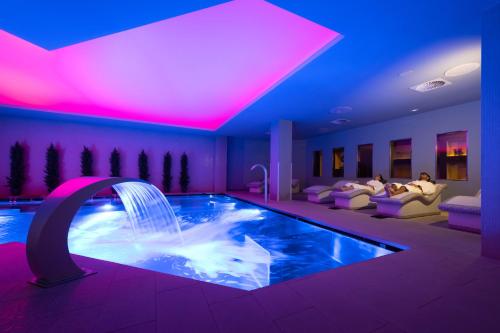 安道尔城Grand Plaza Hotel & Wellness的酒店客房带游泳池,带喷泉