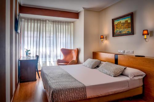 希洪希洪柯斯达旅馆的一间卧室配有一张带椅子的床和一扇窗户