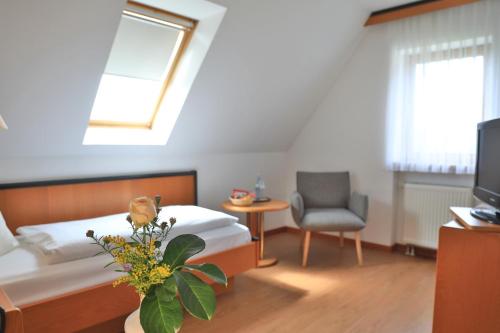 科琴斯顿巴赫苏姆阿特施罗斯兰迪伊尔酒店的一间卧室配有一张床、一把椅子和电视。