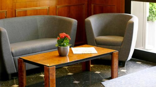 科隆依贝茨嘉利酒店的两把椅子和一张桌子,上面有花瓶