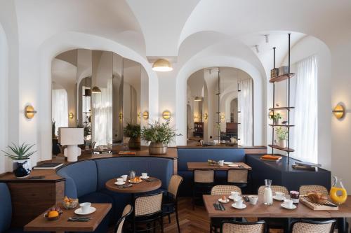 巴黎Hotel Le Friedland的餐厅设有桌椅和镜子