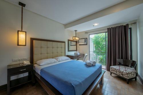 独鲁万罗斯温尼尔酒店的卧室配有床、椅子和窗户。