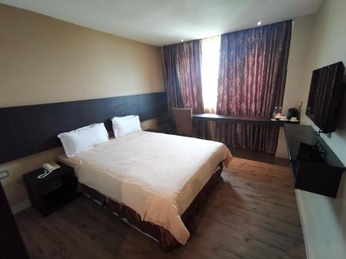 拿笃Hotel De Leon II的一间卧室设有一张大床和一个窗户。