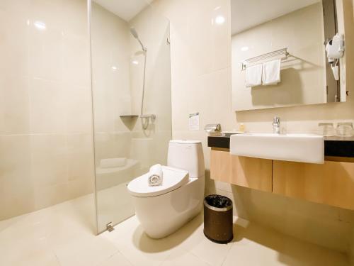 雅加达格瑞帕瑞格酒店的浴室配有卫生间、盥洗盆和淋浴。