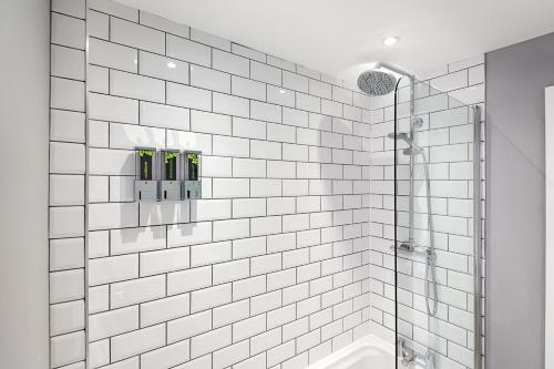 拉内利Murray Nest #1 - TV in Every Bedroom!的白色瓷砖浴室设有淋浴和浴缸。
