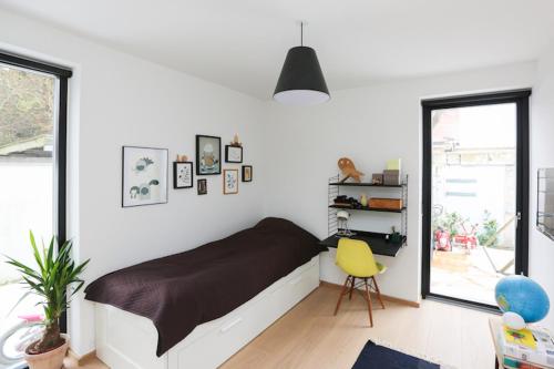哥本哈根Modern architecture atrium house的一间卧室配有一张床和一张黄色椅子