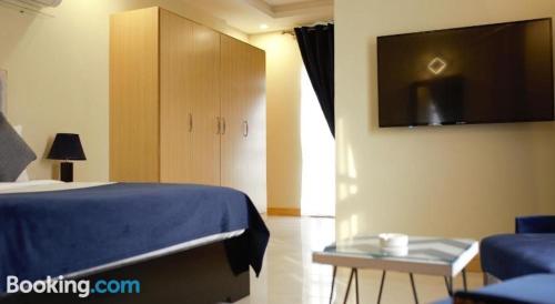 伊斯兰堡Atlas hotel的卧室配有一张床,墙上配有电视。